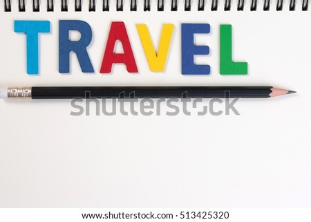 Travel word write on wooden alphabet and notebook on white background. The colorful word wooden travel with pencil on notebook background. The word travel paper. Travel word concept.