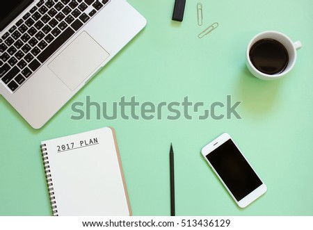 2017 plan on notebook on creative flat lay design of workspace desk with laptop,  smartphone, coffee, office items with copy space background