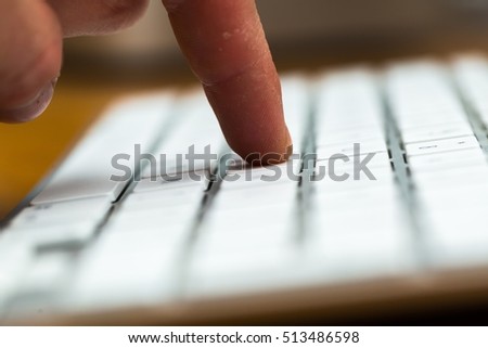 Close up of white wireless aluminum keyboard photographed with shallow depth of field.