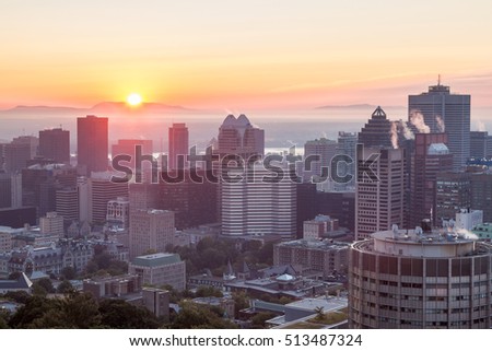 Spectacular sunrise on a foggy summer day over the Montreal skyline seen from the Mount-Royal, Canada