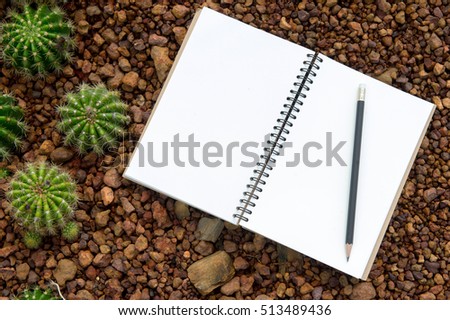 View from above of office supplies on a nature background. blank notebook, black pencil.