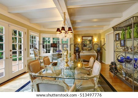 Lovely victorian style dining room interior with glass table , traditional old antique chairs and vintage classic design chandelier. Northwest, USA