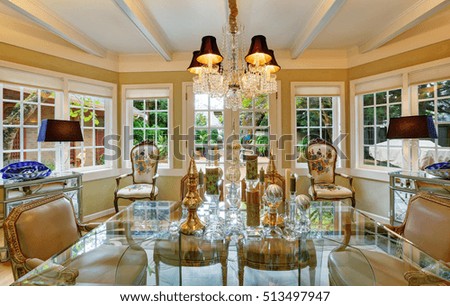 Lovely victorian style dining room interior with glass table , traditional old antique chairs and vintage classic design chandelier. Northwest, USA