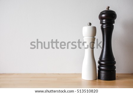 Modern Salt and Classic pepper grinders, standing on wood texture table, front view Royalty-Free Stock Photo #513510820