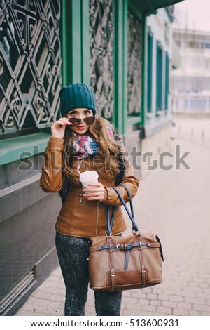 beautiful model walks through the city in a beautiful hat and glasses