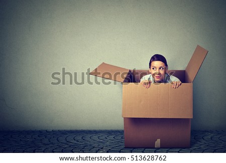 Young woman coming out from a box