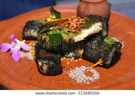 Charcoal/slow cooked/ grilled / spiced tapioca/cassava and dried salted prawn shrimp/prawn fry with green sauce .Kerala, India. Indian spices used. Food served in clay pots/plates/earthenware.