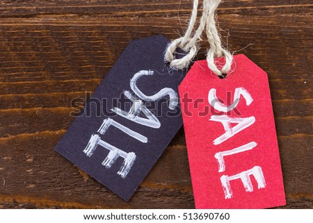 Tags with sale sign on wood board.