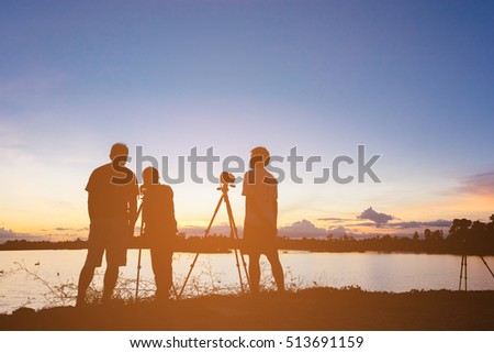 Silhouette photographers with sunset at lake background, Filled color filter.