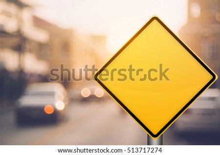 Empty yellow traffic sign on blur traffic road with colorful bokeh light abstract background. Copy space of transportation and travel concept. Retro tone filter color style.