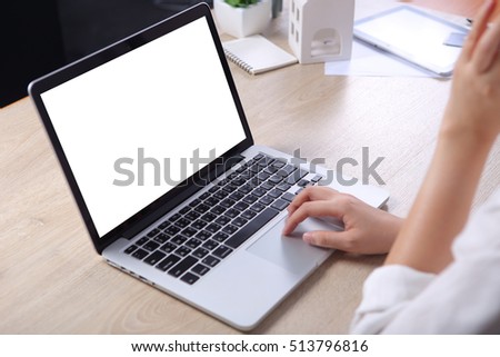 Business woman using mock up laptop on wooden desk
