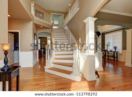 Sunny hallway interior with white staircase and light tones hardwood floor. Northwest, USA