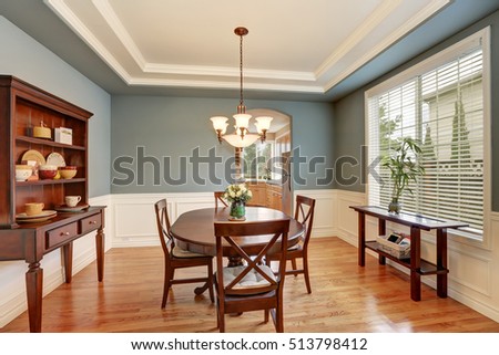 American classic dining room interior with green walls, vintage wooden cupboard, hardwood floor. Decorated with fresh roses in a vase. Northwest, USA