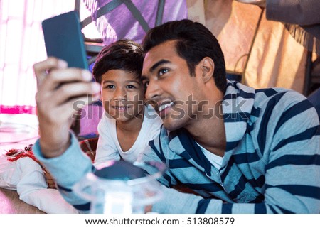 Father and son taking a selfie at home