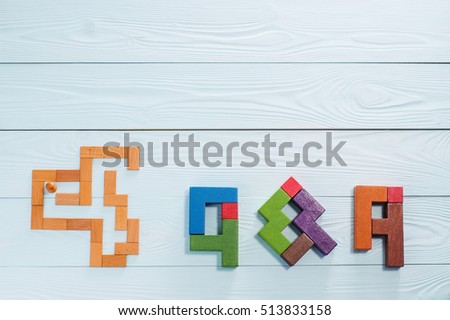 Concept search Answer: the man in the maze and  letters Q & A, made from wooden blocks, top view, flat lay.  Questions and Answers on a wooden background with copy space. 