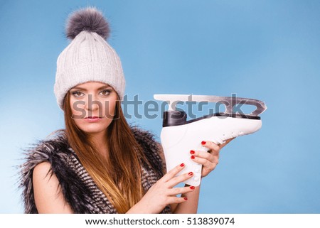 Winter, sport, people concept. Beautiful girl with white skate. Young lady has cap and fur vest.
