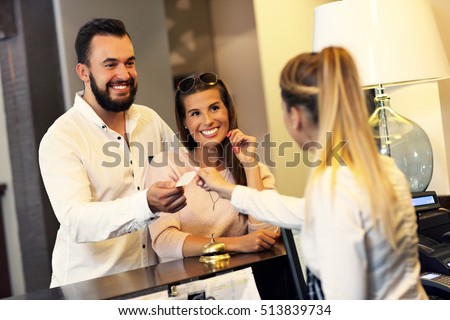 Picture of couple and receptionist at counter in hotel Royalty-Free Stock Photo #513839734