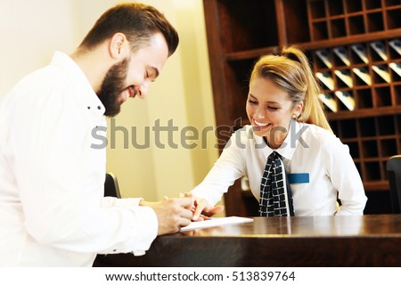 Picture of young businessman signing bill in hotel