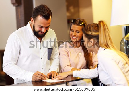 Picture of young businessman signing bill in hotel