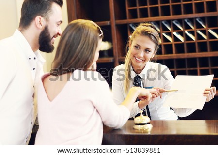 Picture of couple and receptionist at counter in hotel