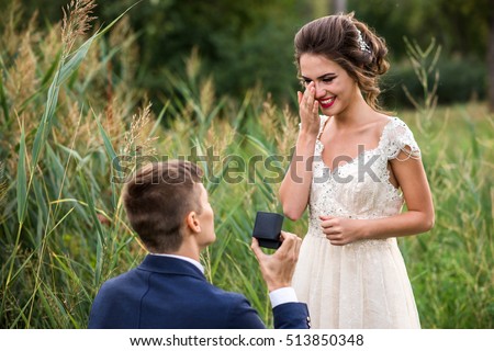 Young man makes a proposal to get married, the bride is crying from happiness Royalty-Free Stock Photo #513850348