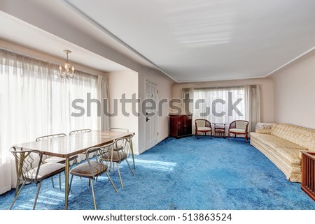 Craftsman style interior. Entrance room connected with dining area. Vintage furniture, dining table for six person and blue soft carpet floor. Northwest, USA