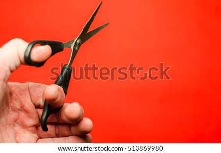 scissors in hand on a red background