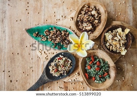 Variety of green buckwheat granola with berries and dries fruits in wooden spoons, healthy mindful eating Royalty-Free Stock Photo #513899020