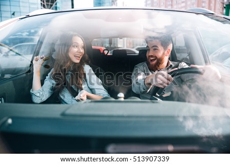 Enjoy couple in car. man at the wheel. front view. eyes to eyes