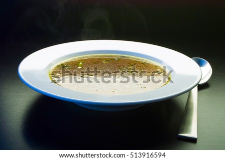 Ladle broth to the pan with the broth background top view 