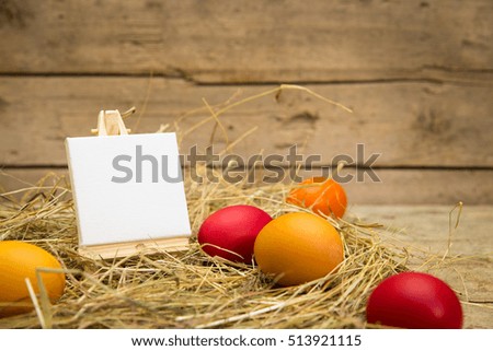 easter nest with yellow and red eggs, empty canvas for text, wooden background