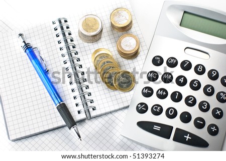 A calculator, a pen and stacks of euros isolated on a white background