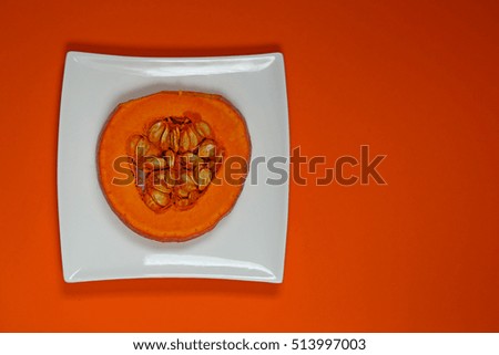 Pumpkin piece on a white plate on an orange background