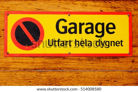 Sign stating that it is no parking, driveway with text written in Swedish, "Garage, driveway all day."
