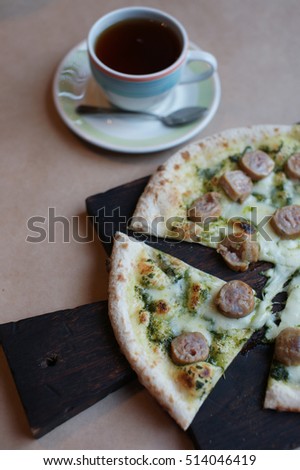 Pizza with sausage on the table in the restaurant.