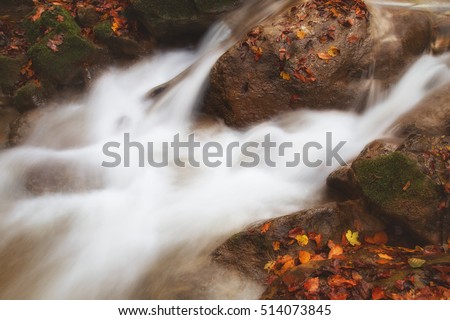 Small waterfall rolling past stones