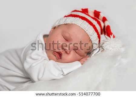 Newborn baby on white background in a Christmas Santa hat