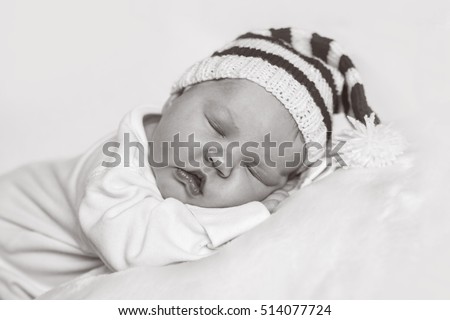 Newborn baby on white background in a Christmas Santa hat