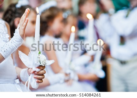 Hands with candles of little girls on first holy communion Royalty-Free Stock Photo #514084261