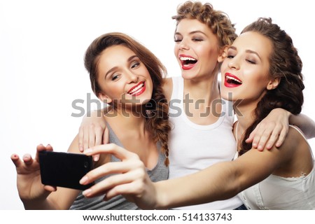 friendship, people and technology concept - three happy teenage girls with smartphone taking selfie