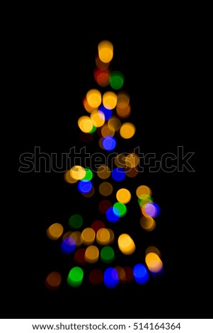Colorful blurred christmas tree lights isolated on black backdrop. Creative background photography.