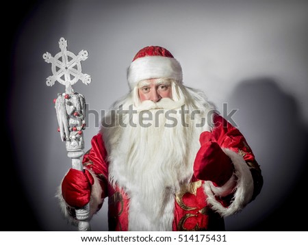 Traditional Christmas Santa Claus with staff on a gray background