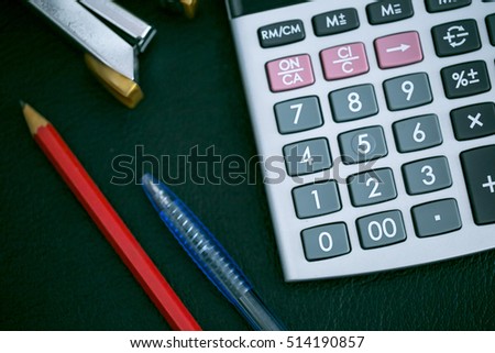 Close up image of calculator, pencil and pen.