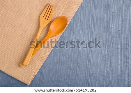 wood spoon and wood fork on table top view and blue table cloth for food book design, food menu and web-site background