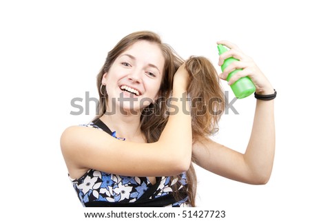 Beauty girl spraying hair lacquer onto her hair over white