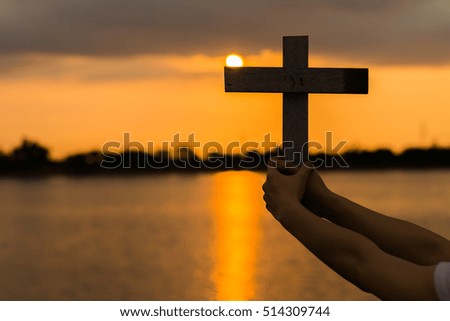 Silhouette wood cross or religion symbol shape over a sunset sky with clouds background for God, Christ, Christianity, religious, faith, holy, spiritual, Jesus, belief or resurection