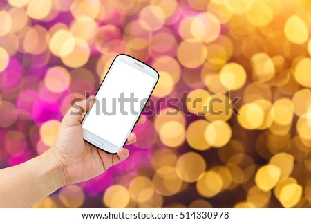 Close up woman hand holding mobile (smart phone) over blurred image of bokeh background
