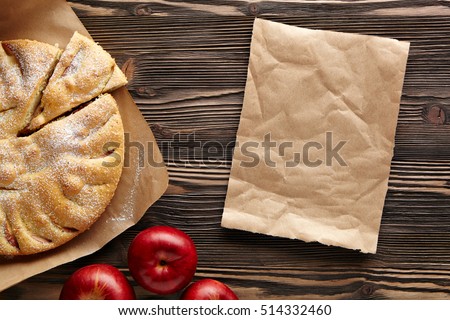 Apple pie on a wooden rustic table. Top view.  Piece kraft paper empty space for text. Royalty-Free Stock Photo #514332460