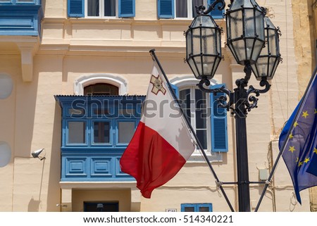 Malta and EU flag in front of traditional Maltese blue balcony's, with old lampost, Valletta, Malta Royalty-Free Stock Photo #514340221