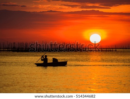 Silhouettes of the traditional stilt fishermen at sunset